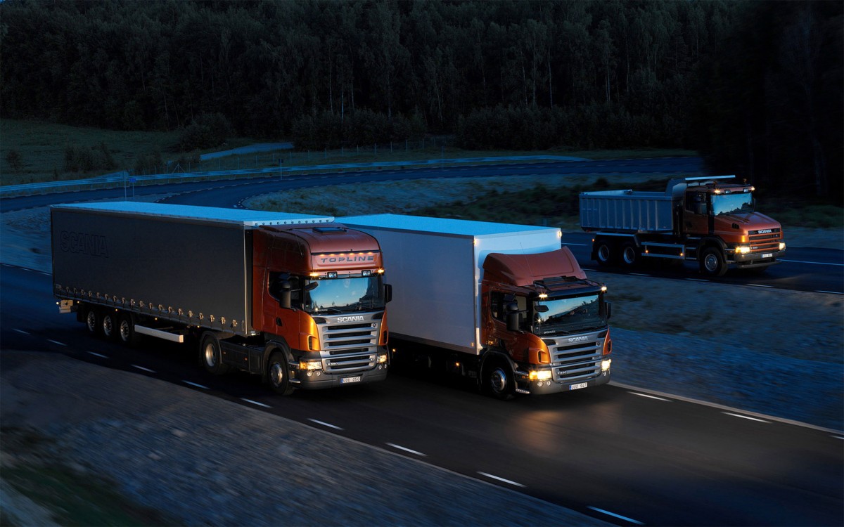 Three-orange-Scania-trucks